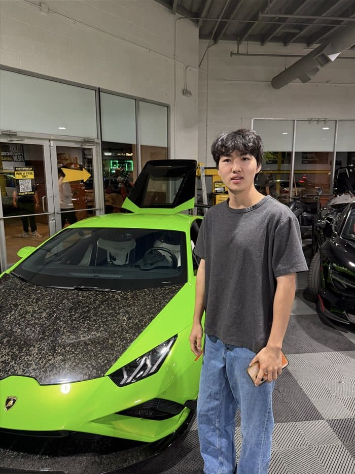 Brandon next to a green Lamborghini with a carbon hood
