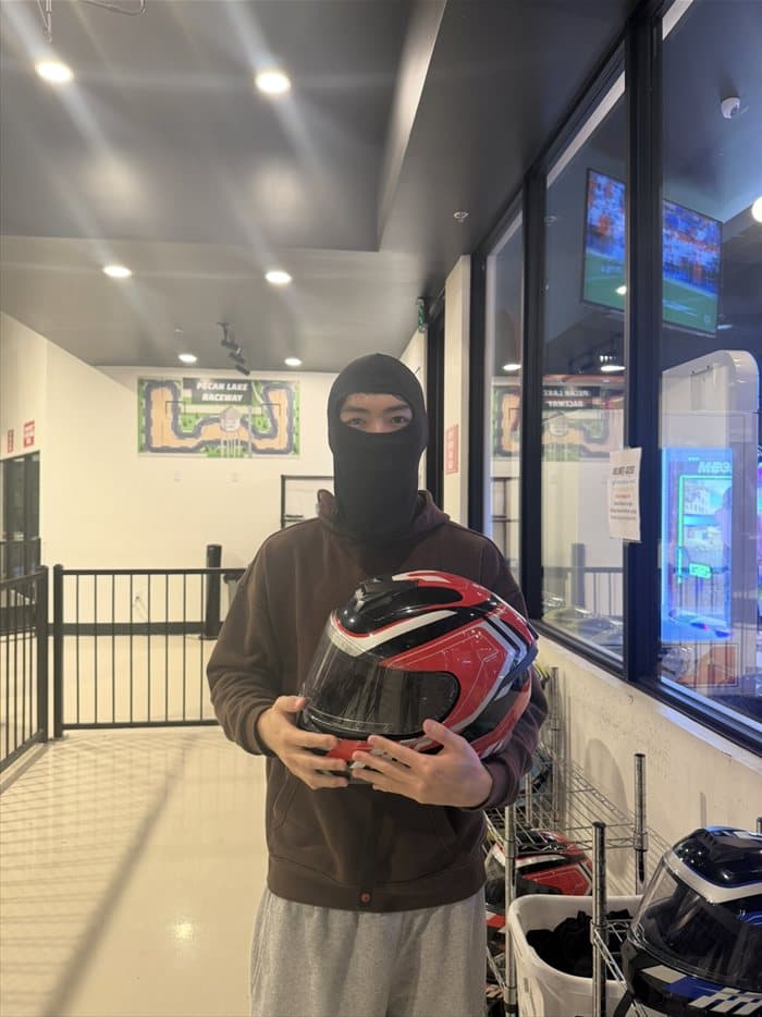 Brandon in a balaclava holding a helmet at Pecan Lake Raceway