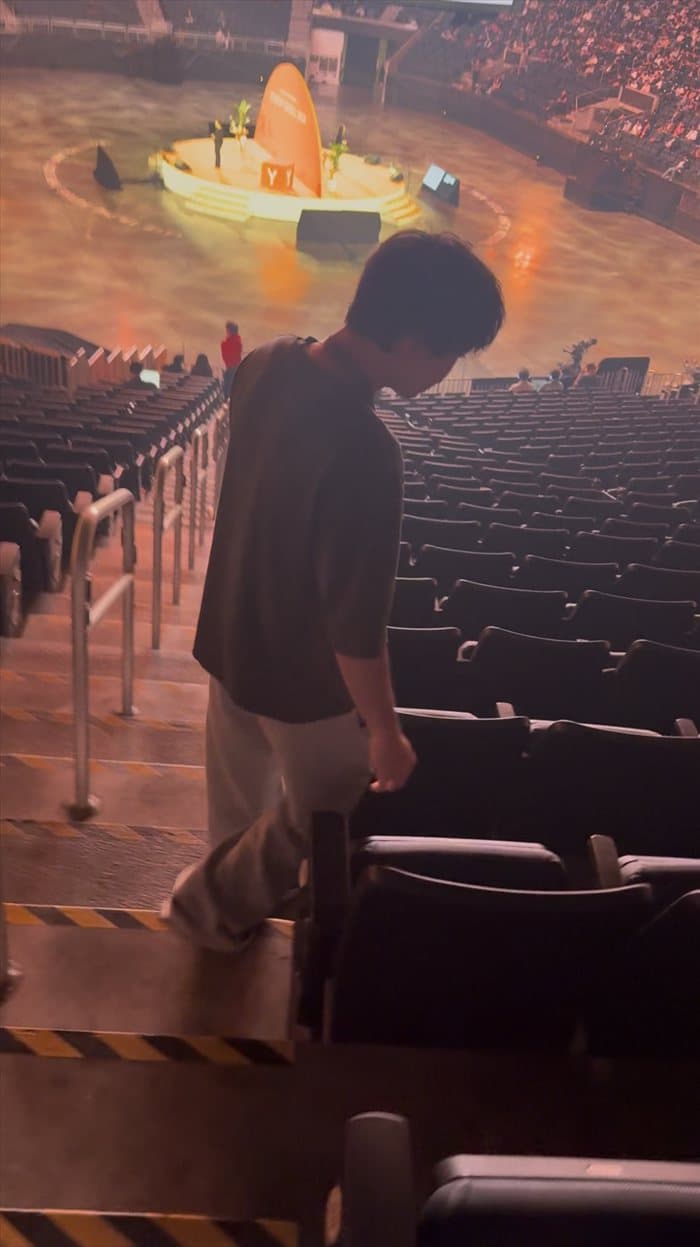 Brandon walking down the arena steps at YC Startup School with the stage below